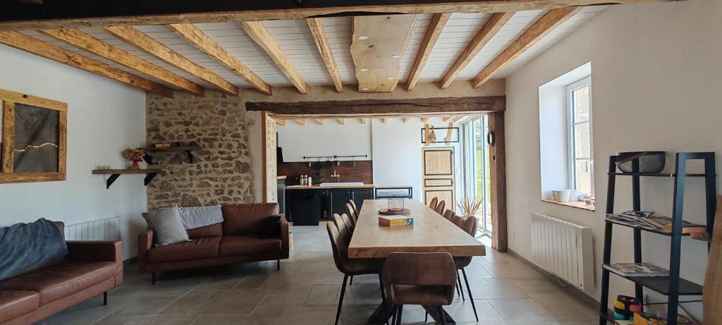a living room with a table and a couch at Gîte de Nath - classé 4 étoiles in Barrais-Bussolles