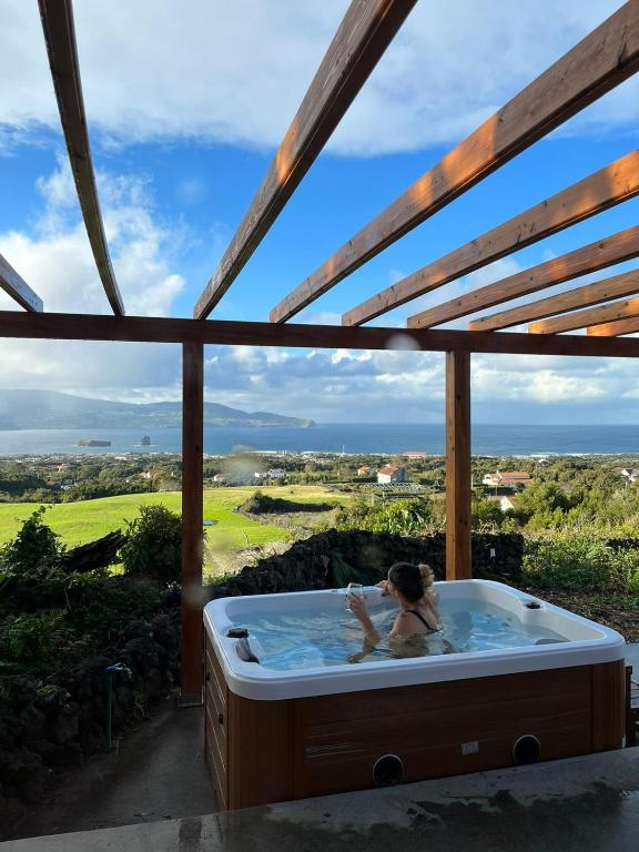 a woman in a jacuzzi tub with a view at Adega da Quinta- Casa do camolas in Madalena