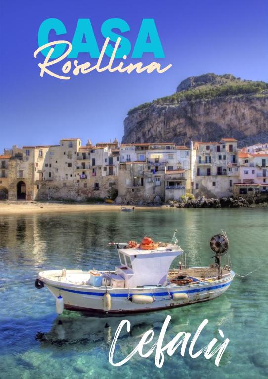 a boat in the water in front of a city at Casa Rosellina in Cefalù