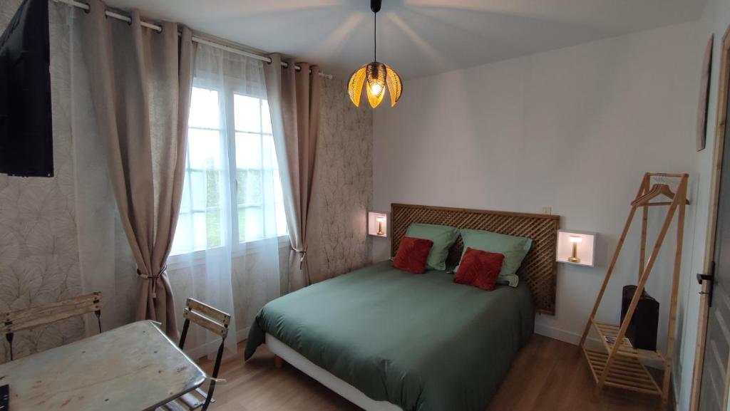 a bedroom with a green bed and a window at Studio jardin st jean de daye in Saint-Jean-de-Daye