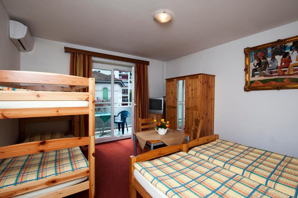 1 Schlafzimmer mit 2 Etagenbetten und einem Schreibtisch in der Unterkunft Hotel Dischma in Lugano