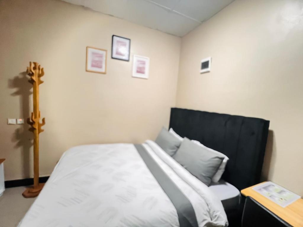 a bedroom with a bed with a black headboard at Convenient city apartment with free WiFi in Dar es Salaam