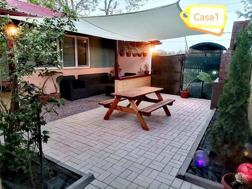 eine Terrasse mit einem Picknicktisch und einem Sonnenschirm in der Unterkunft Casa Dașoveanu in Sulina