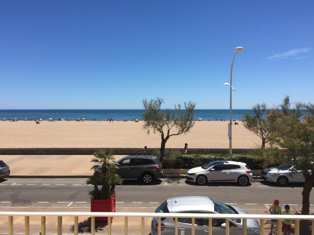 - un parking à côté d'une plage avec des voitures dans l'établissement Front de mer 100m2 Vue magnifique, balcon, jardin, garage, à Valras-Plage