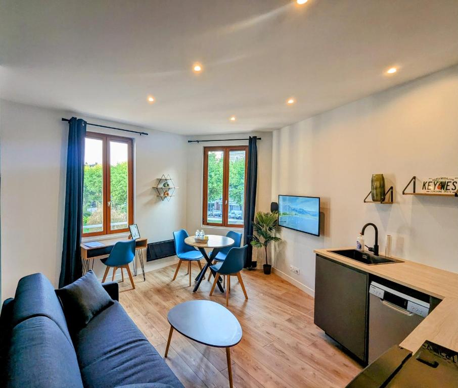 un salon avec un canapé bleu et une table dans l'établissement La Flèche Saint Vivien: Hypercentre & Cathédrale, à Rouen