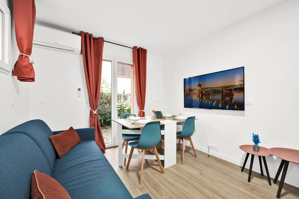 a living room with a blue couch and a table at Douceur d'argile in Toulouse