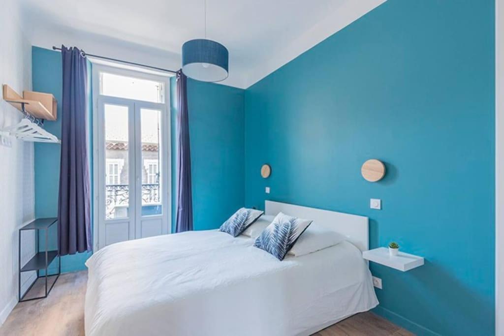 - une chambre bleue avec un lit blanc et une fenêtre dans l'établissement Longchamp - T2 - 10 min de St Charles, à Marseille