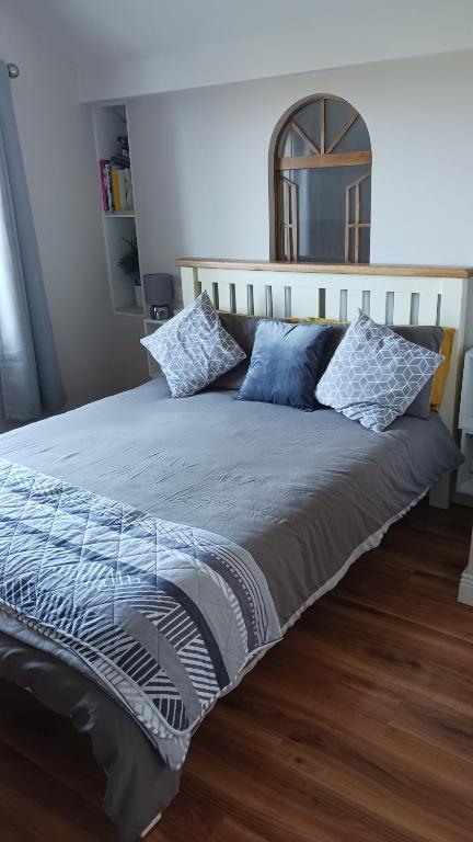 un grande letto con cuscini blu in una camera da letto di Lighthouse View a Tralee