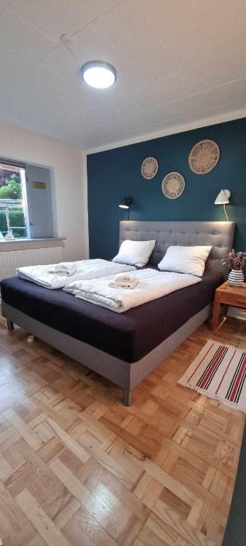 a bedroom with a large bed with a blue wall at The Dream Villa in Rødby