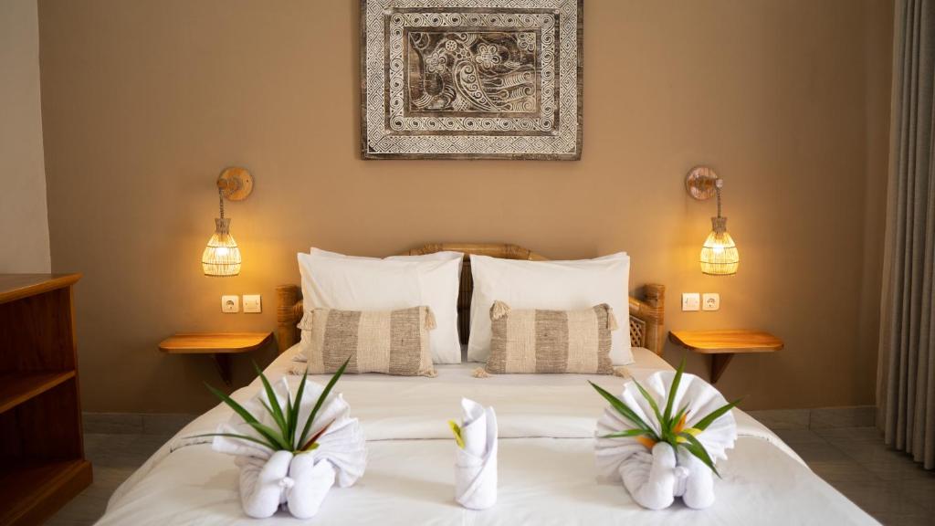 Postel nebo postele na pokoji v ubytování Nucifera Kuta Lombok