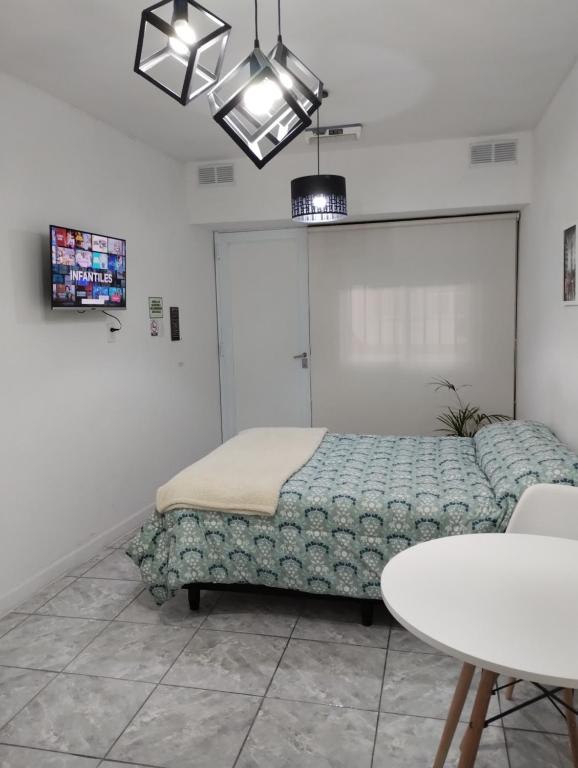 een slaapkamer met een bed, een tafel en een kroonluchter bij Mendoza Estudio Urbano in Mendoza