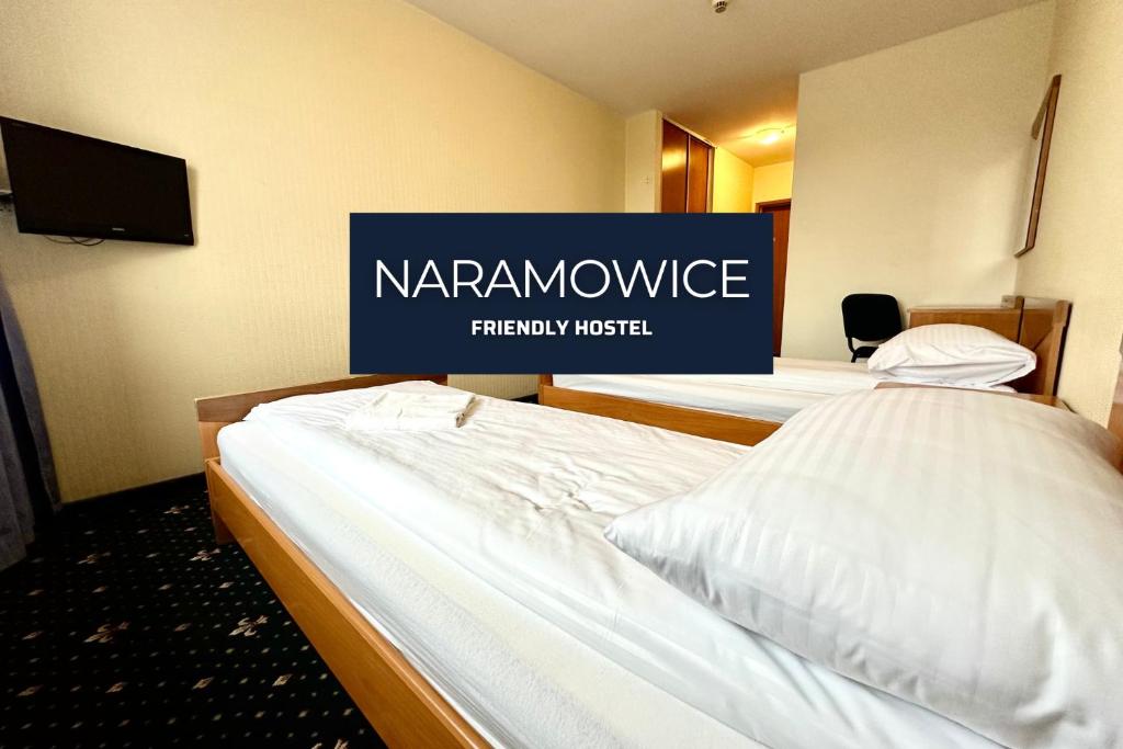 duas camas num quarto de hotel com um letreiro que diz "hotel terapêutico de resposta" em NARAMOWICE Hostel by Friendly Hostel em Poznań