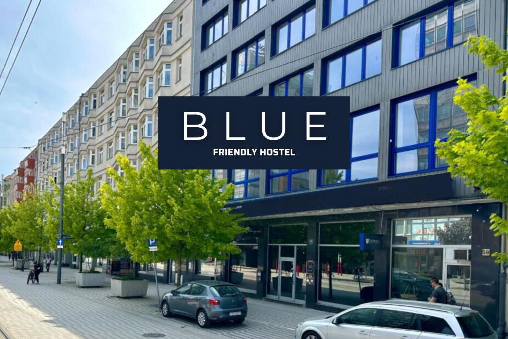 a blue sign on the side of a building at BLUE Hostel - Private Rooms by Friendly Hostel in Poznań