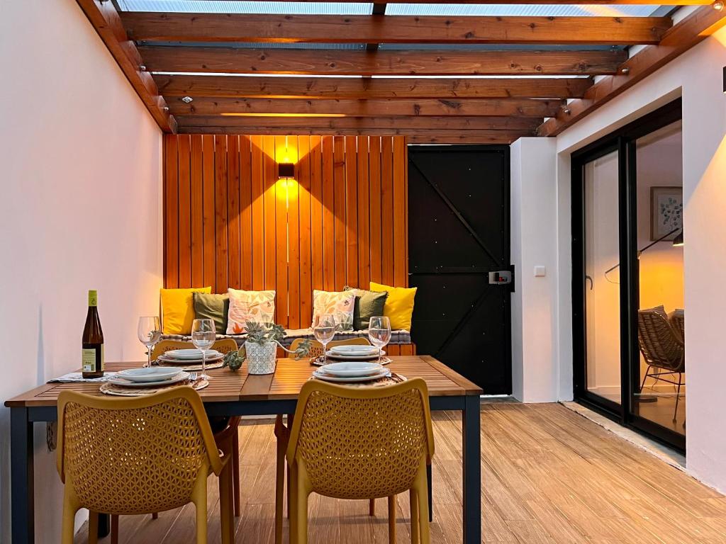 a dining room with a wooden table and chairs at Domus Vallis in Furnas