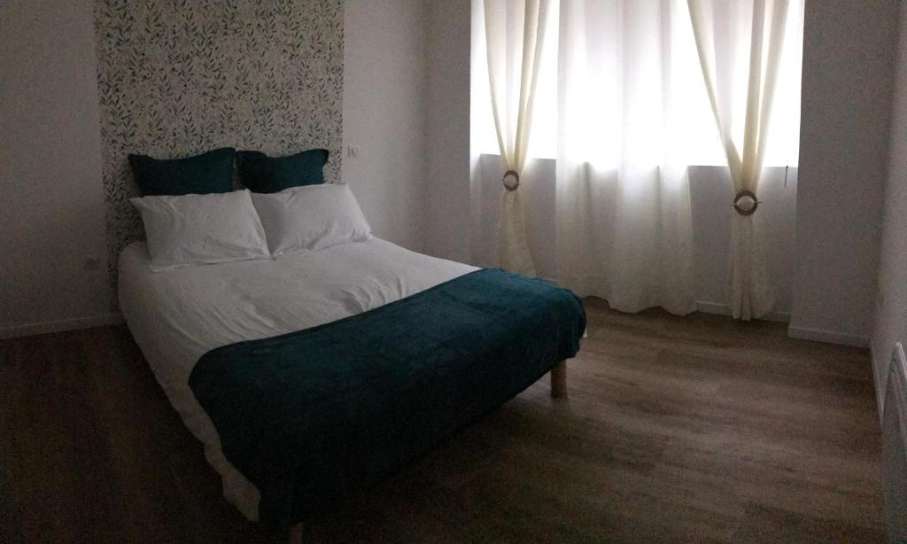 une chambre avec un grand lit avec une fenêtre dans l'établissement Au cœur de la ville, à Lourdes
