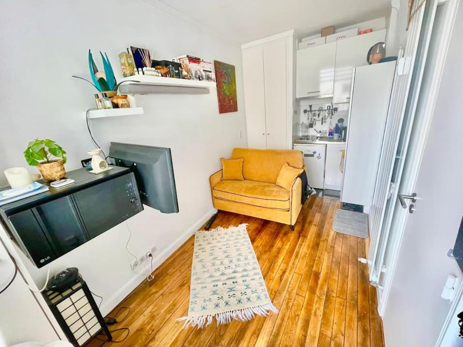 un salon avec un canapé et une télévision dans l'établissement La perle rare du 7e, à Paris