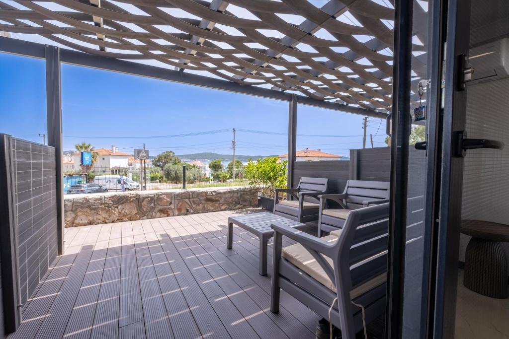 a patio with benches and a view of the ocean at Select Cunda Guest House - Sea View Room with Private Veranda in Cunda Island in Ayvalık
