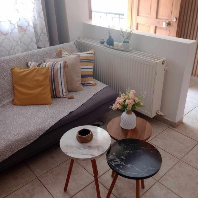 a living room with a couch and two tables at Ameli House in Neoi Epivates