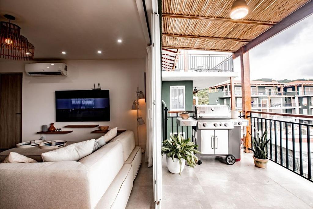 uma sala de estar com um sofá e uma televisão na varanda em Blue Venao CONDO APARTMENT C32 em Playa Venao
