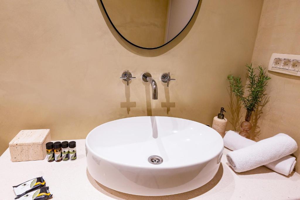a white sink in a bathroom with a mirror at Boutique hotel Ruzmarin SPA & Garden by Aycon in Budva