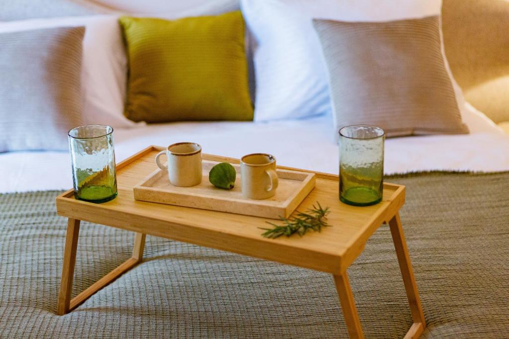 a wooden table with two glasses and a tray with drinks on it at Boutique hotel Ruzmarin SPA & Garden by Aycon in Budva
