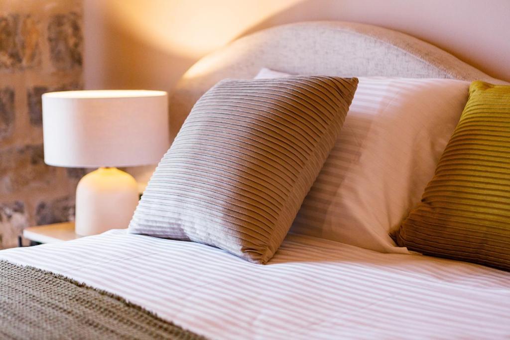 a bed with two pillows on top of it at Boutique hotel Ruzmarin SPA & Garden by Aycon in Budva