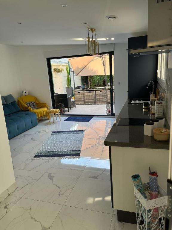 une cuisine et un salon avec un canapé et une table dans l'établissement Location Studio Luxe Villejuif, à Villejuif