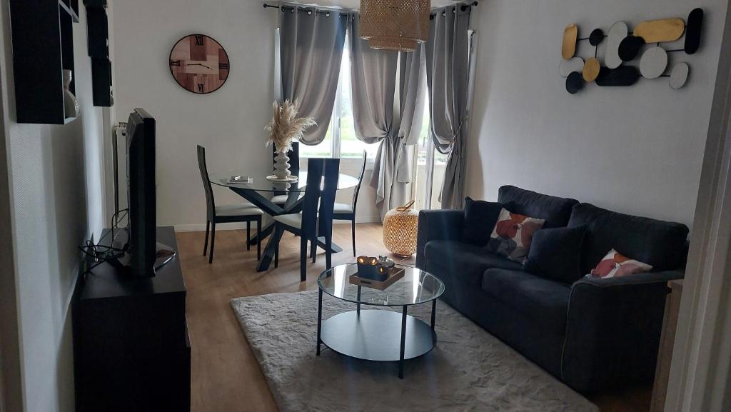 uma sala de estar com um sofá e uma mesa em Azur em Toulouse