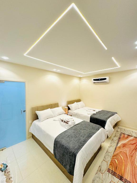 two beds in a room with a ceiling at Dima Pyramids View in Cairo