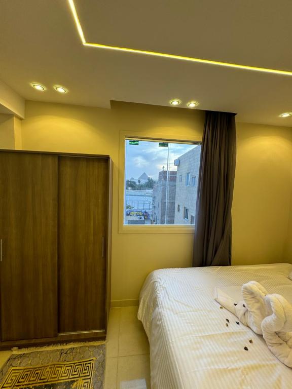 a bedroom with a bed and a window at Dima Pyramids View in Cairo