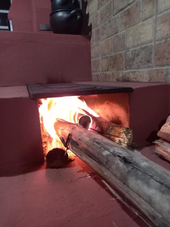 a brick oven with a fire in it at Casa Espaço Sara Piscina Aquecimento Solar total privacidade, área gourmet completa com churrasqueira fogão a lenha, a 5min do centro e do parque das águas in São Lourenço