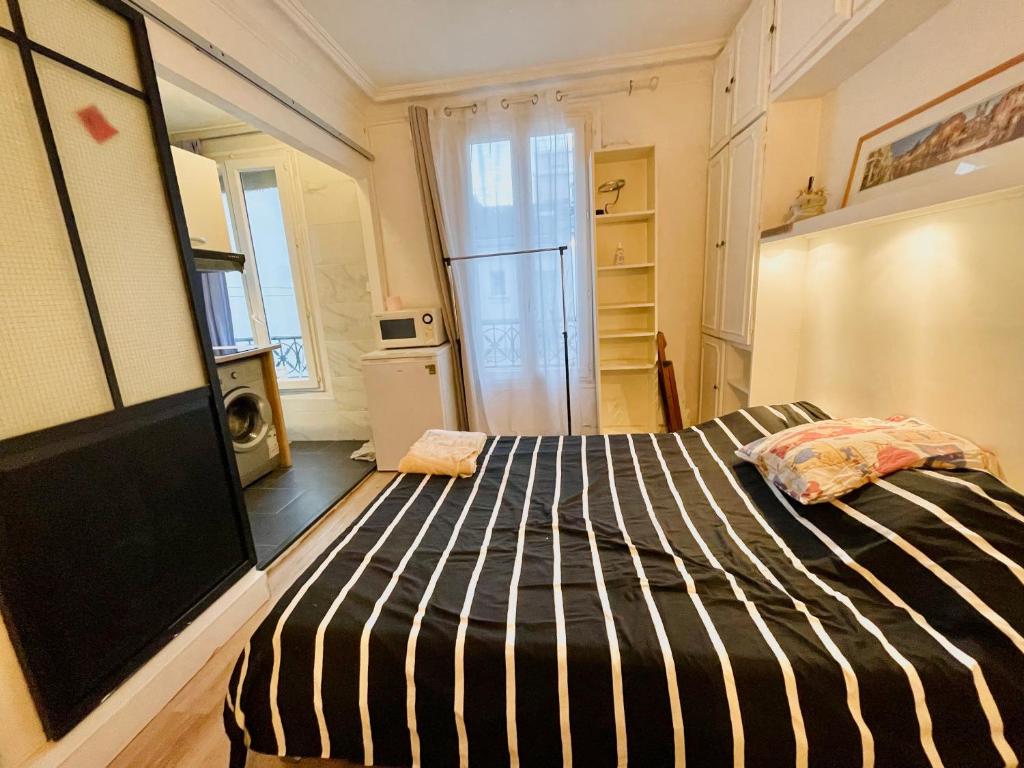 une chambre avec un grand lit dans une pièce dans l'établissement Studio Paris 15e G Tour Eiffel Roland Garros, à Paris