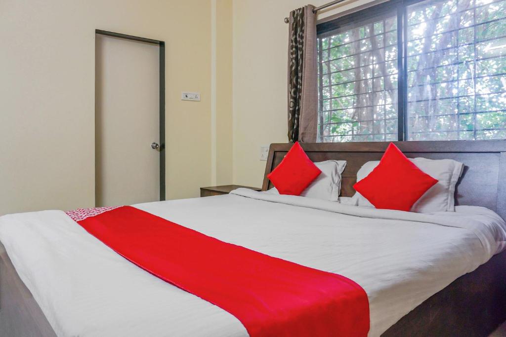 a bedroom with a large bed with red pillows at Super OYO Flagship Hotel Mv Galaxy in Dāpuri