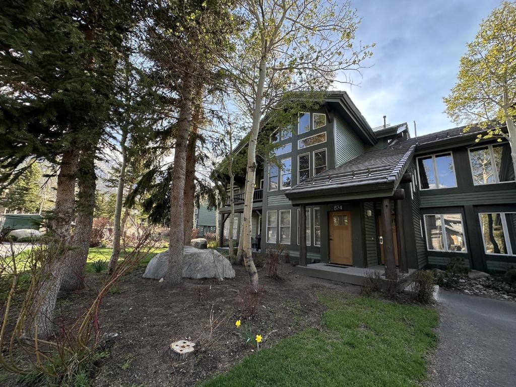 a green house with trees in front of it at Snowcreek V #874 condo in Mammoth Lakes