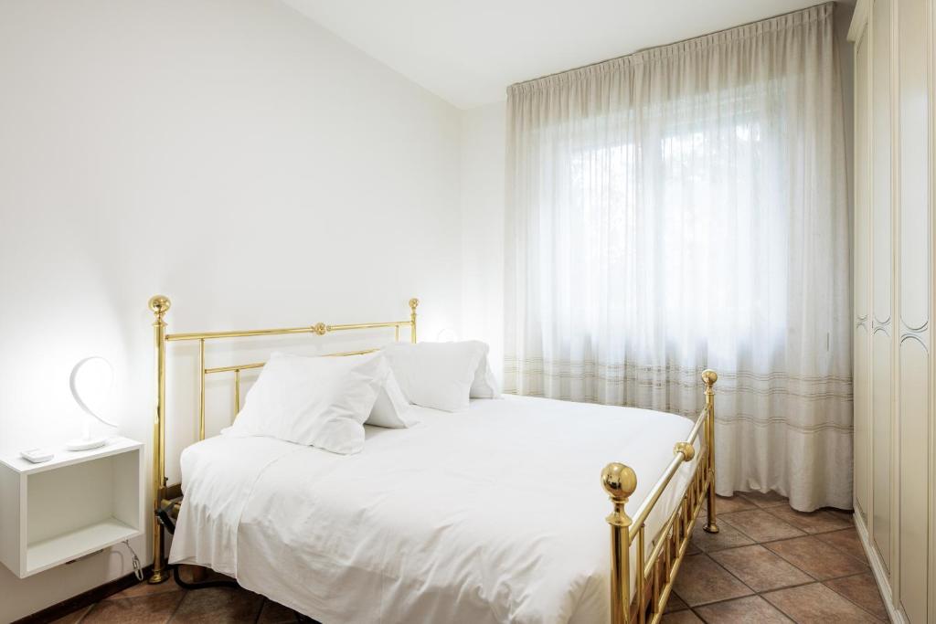 a bedroom with a white bed and a window at Affittacamere Casa Emilia Foresteria Lombarda in Ponte San Pietro