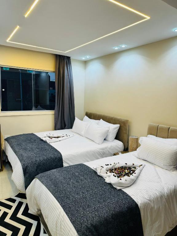 two beds in a hotel room with at Dima Pyramids View in Cairo