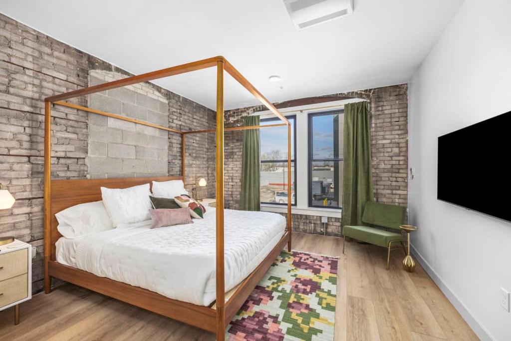 a bedroom with a canopy bed and a tv at BlueJay Hotel in Grand Rapids