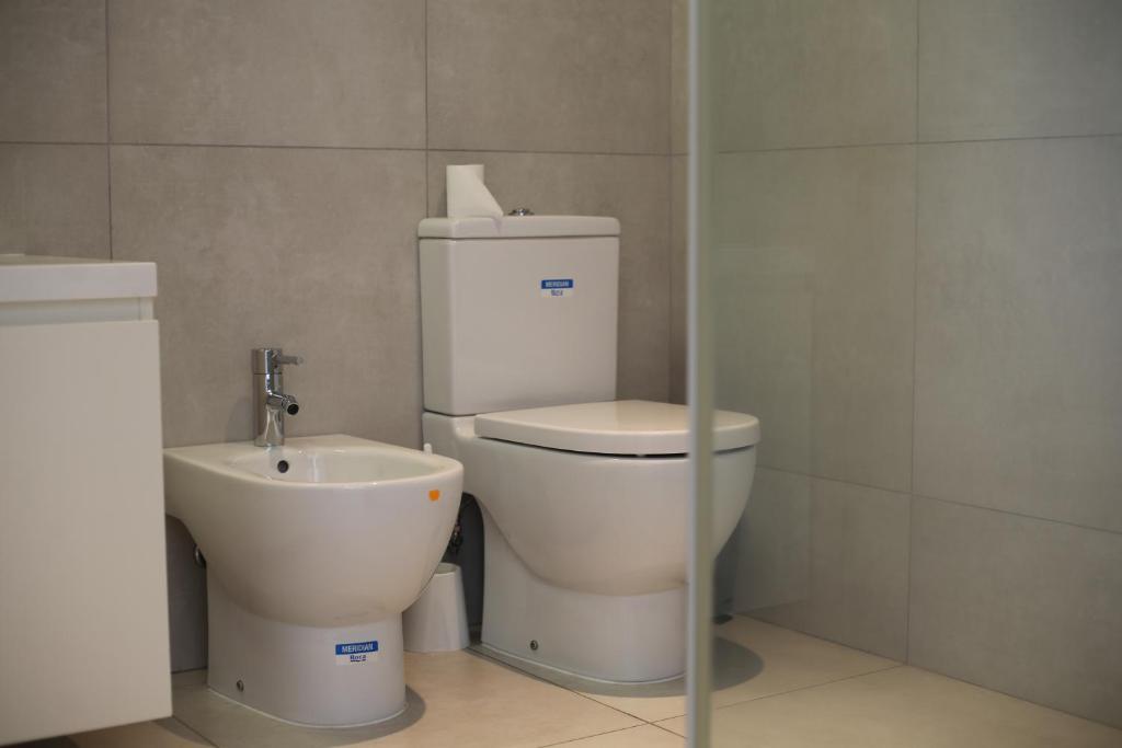 La salle de bains est pourvue de toilettes et d'un lavabo. dans l'établissement Island, Pool & Sea Apartment, à Chicala