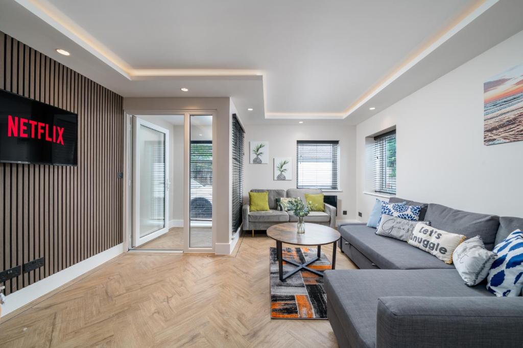 a living room with a couch and a table at Skyvillion - COZY LARGE 4 & 1 Bed Apartments in London Enfield, Mins to Tube Station, Free Wi-Fi in Cockfosters
