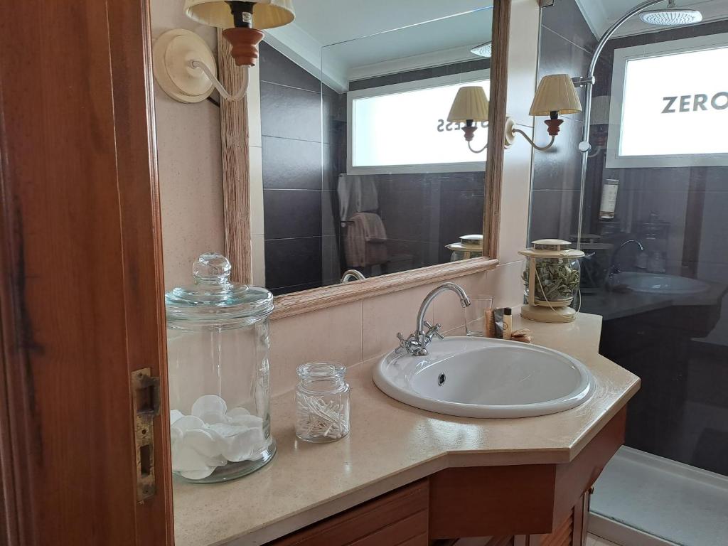 a bathroom with a sink and a mirror at SaberAmar Charme in Aveiro