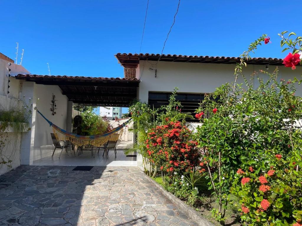 un patio con una hamaca en una casa con flores en Casa super arejada no melhor de Miramar, en João Pessoa