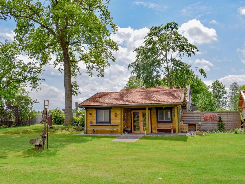 ein kleines gelbes Haus auf einem Grasfeld in der Unterkunft Onder de oude Eik in Lottum