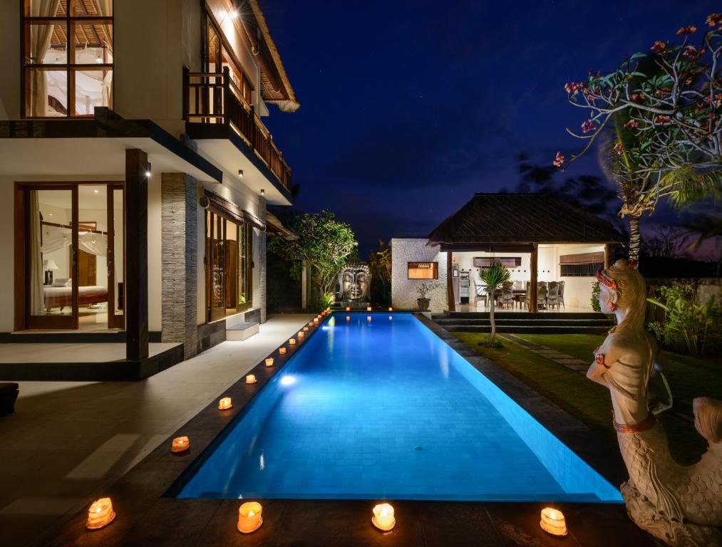 una piscina en el patio trasero de una casa por la noche en Balangan Beach Villa, en Jimbaran