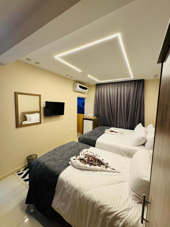a hotel room with two beds and a tv at Dima Pyramids View in Cairo