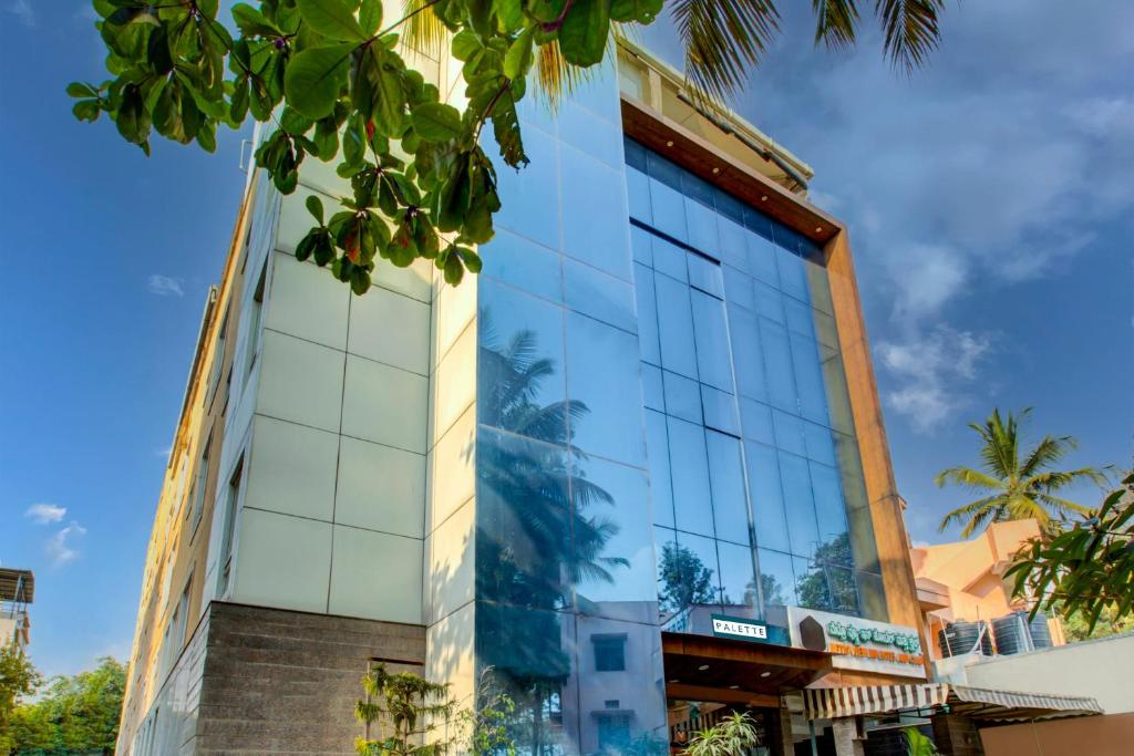 een gebouw met glazen ramen aan de zijkant bij Townhouse Oak JVH hotel (Next to Mysore Road Metro Station) in Bangalore