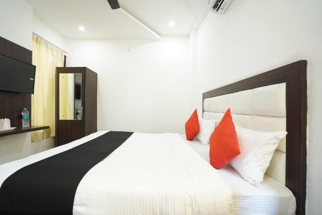 Karnal的住宿－Hotel Star Inn，卧室配有带红色枕头的大型白色床