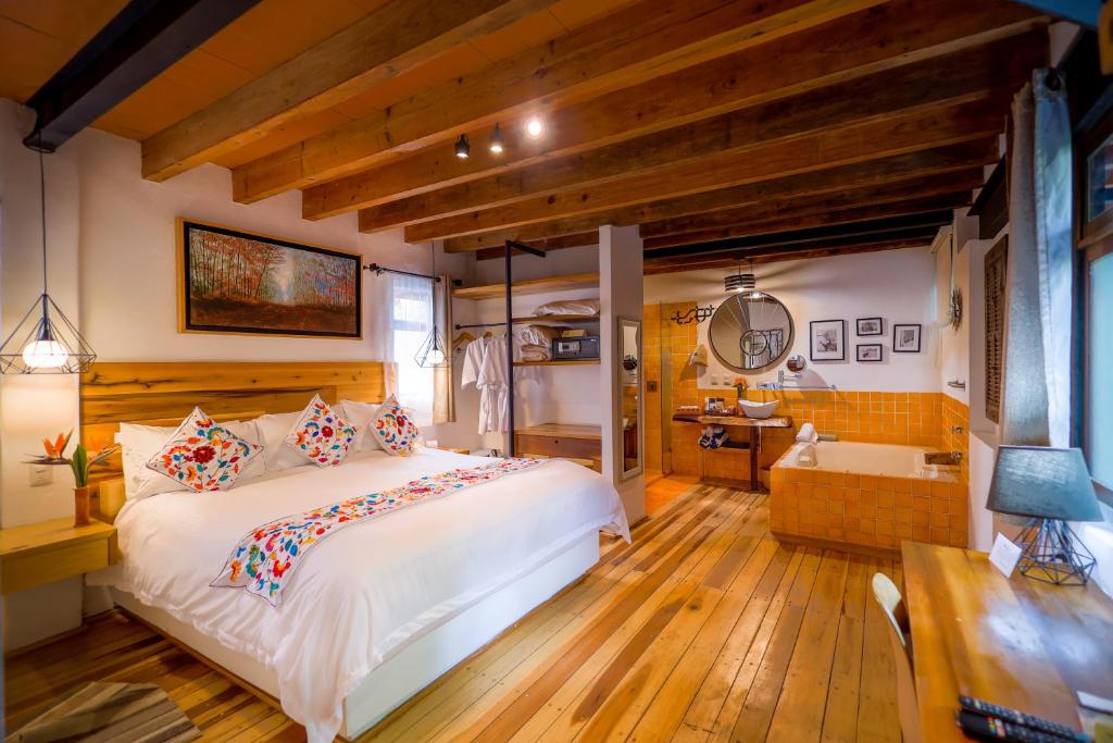 una camera con un grande letto e una vasca da bagno di Mesón De Leyendas Breakfast & Downtown a Valle de Bravo