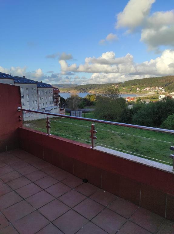 a balcony with a view of a field and buildings at Apartamento Mar-Azul in Laxe