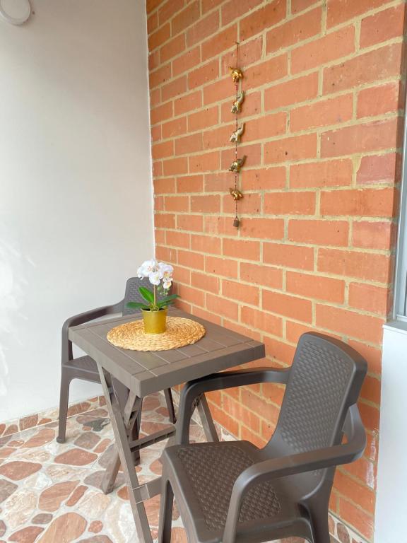 a table and two chairs next to a brick wall at casa vacacional en Anapoima in Anapoima