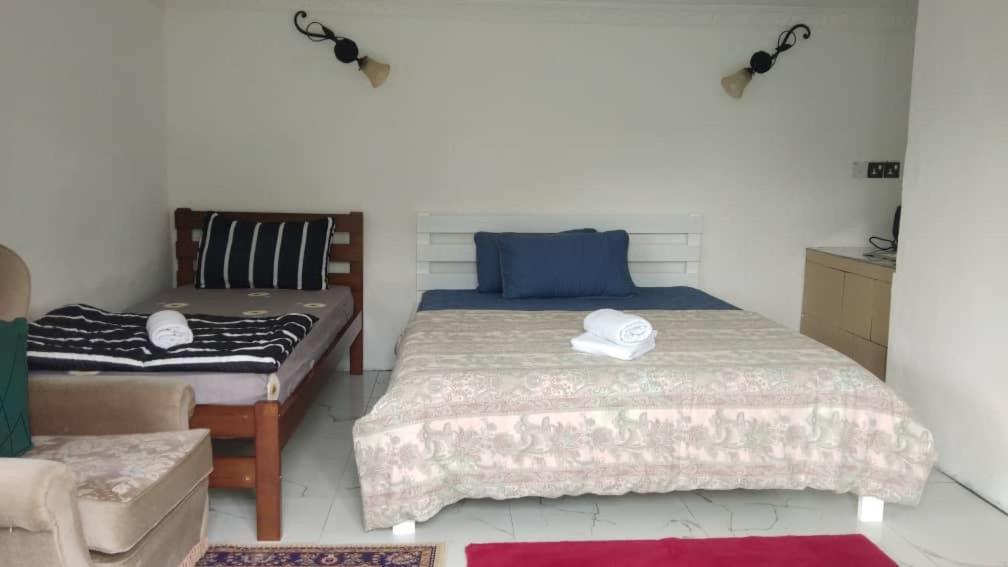 ein Schlafzimmer mit einem Bett und einer Couch in der Unterkunft Spectacular Mt Kinabalu view 2 Bedroom cottage in Ranau